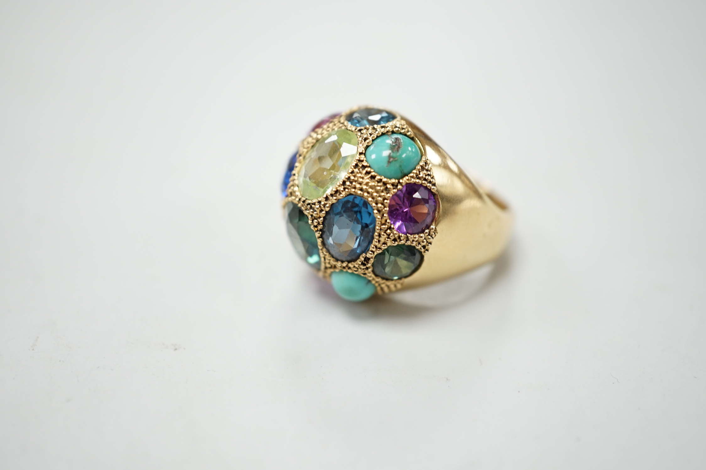 A Middle Eastern yellow metal and multi gem set domed dress ring, size K/L, gross weight 10.5 grams.
